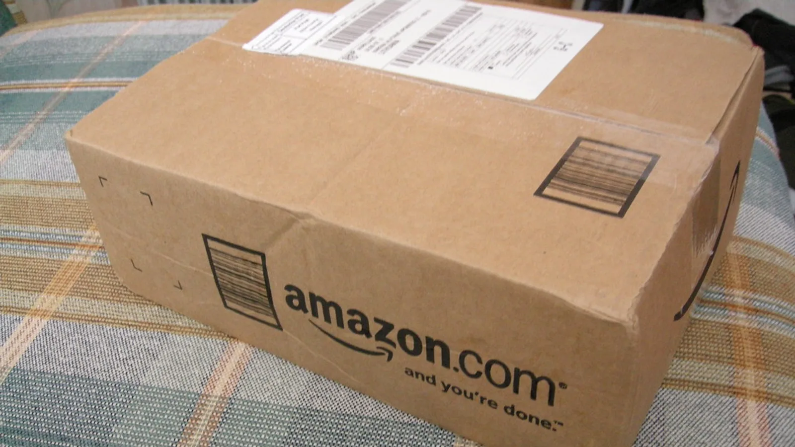 Stack of Amazon-branded cardboard delivery parcels outside a residential door