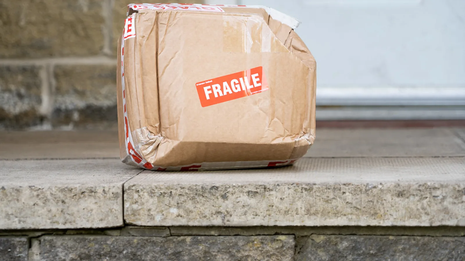 Cardboard parcel from an online order left on a residential doorstep.